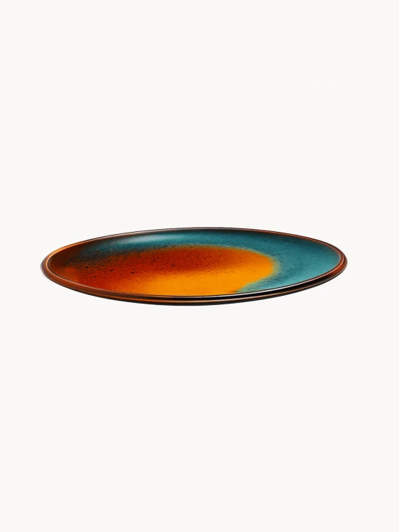 Płaski ceramiczny talerz pokryty żywym, artystycznym szkliwem, w którym ognisty pomarańczowy środek przechodzi w głęboki morski brzeg.